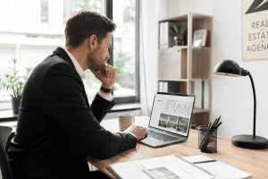 Agent immobilier consultant un logiciel d'estimation immobilière dans son agence